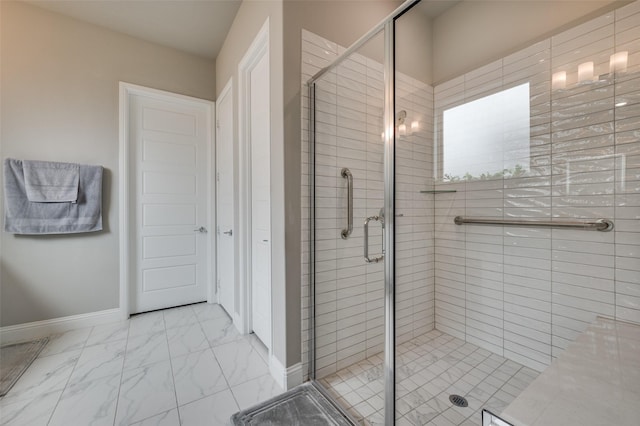 full bathroom featuring baseboards, marble finish floor, and a shower stall