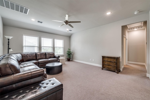 living area with visible vents, attic access, baseboards, and ceiling fan