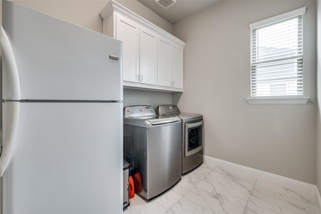 clothes washing area featuring cabinet space, marble finish floor, baseboards, visible vents, and washer and clothes dryer