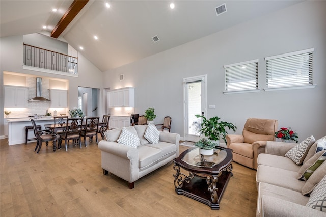 living room featuring visible vents, high vaulted ceiling, beamed ceiling, light wood-style floors, and recessed lighting