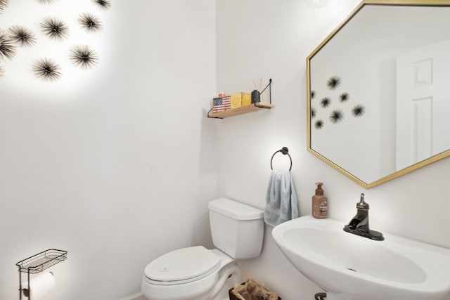 half bath featuring toilet and a sink