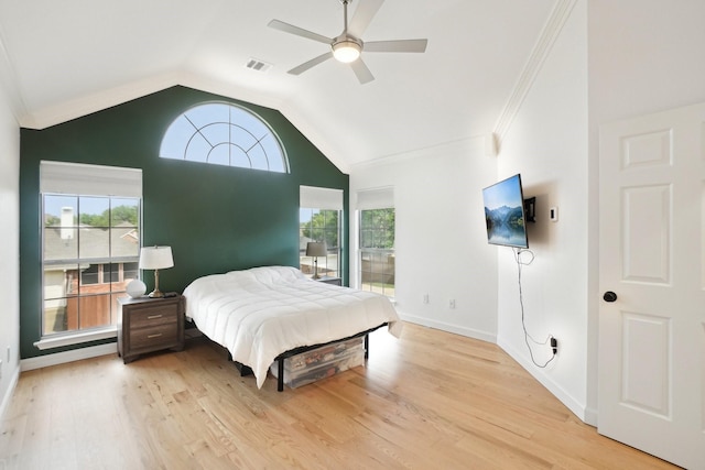 bedroom with ornamental molding, light wood-style flooring, vaulted ceiling, and multiple windows