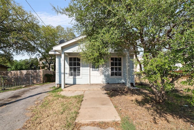 view of front facade featuring a porch, aphalt driveway, and fence