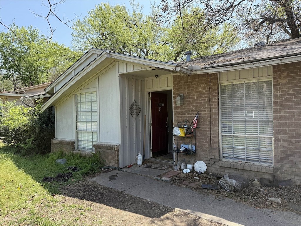 doorway to property featuring brick siding