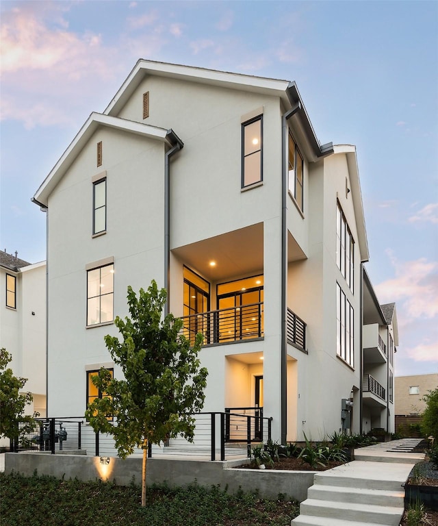 rear view of house featuring stucco siding