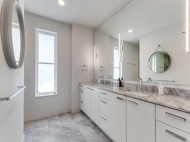 bathroom featuring a sink, baseboards, recessed lighting, and marble finish floor