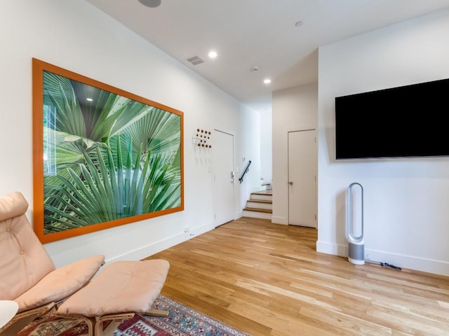 living area with visible vents, light wood-style floors, baseboards, stairway, and recessed lighting