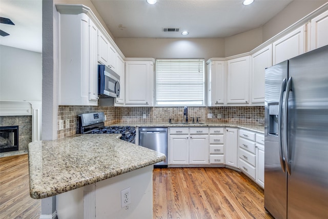 kitchen featuring appliances with stainless steel finishes, a sink, visible vents, and light wood-style floors