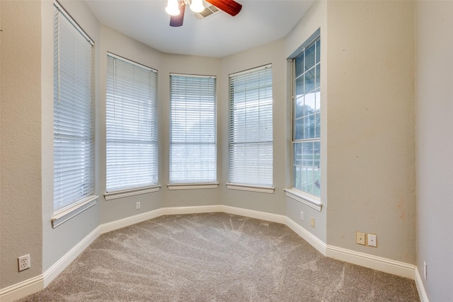 unfurnished room featuring carpet flooring, a ceiling fan, baseboards, and visible vents