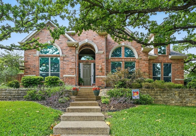 view of front of property with brick siding and a front yard