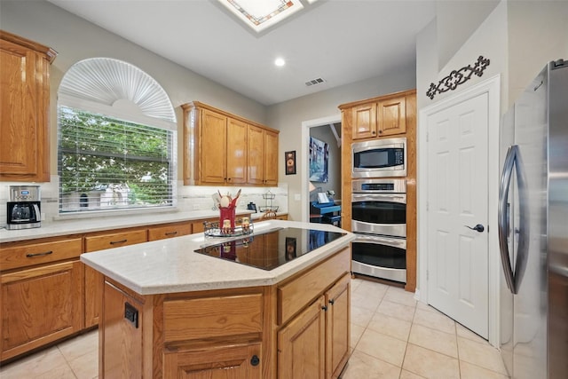 kitchen with appliances with stainless steel finishes, light countertops, light tile patterned floors, backsplash, and visible vents