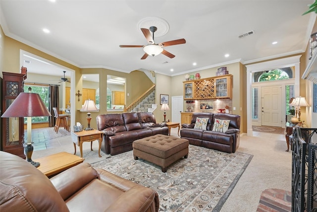 living room featuring ceiling fan, visible vents, crown molding, stairs, and recessed lighting