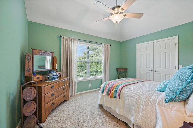 bedroom featuring baseboards, ceiling fan, a closet, and light colored carpet