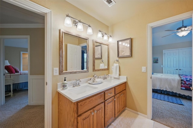 bathroom featuring visible vents, a sink, crown molding, and ensuite bath