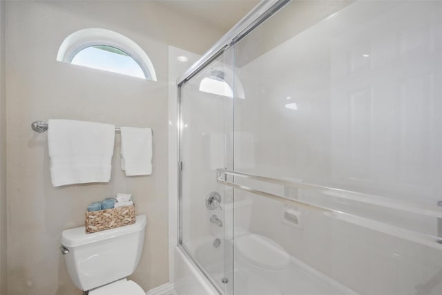 full bath featuring combined bath / shower with glass door and toilet