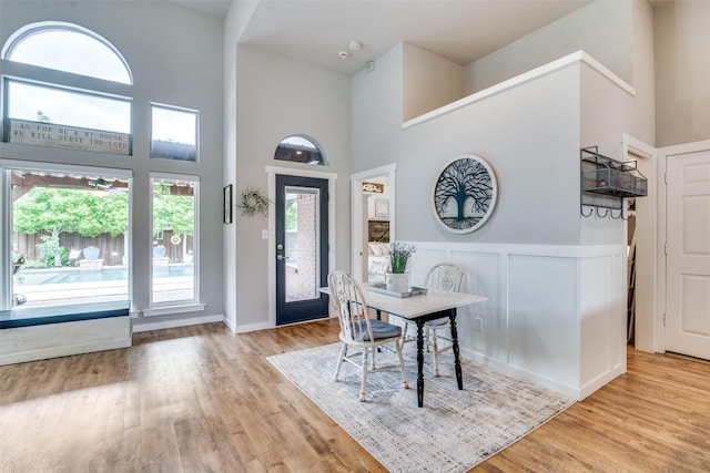 dining room with a high ceiling and light wood-style flooring