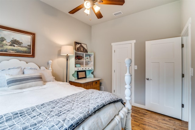 bedroom with baseboards, ceiling fan, visible vents, and light wood-style flooring