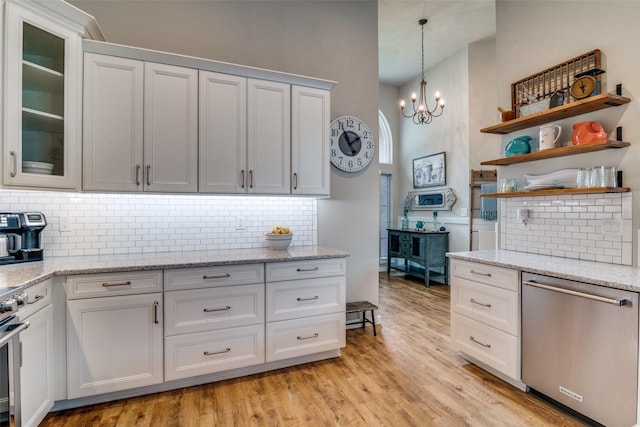 kitchen with light wood finished floors, a high ceiling, tasteful backsplash, and stainless steel appliances