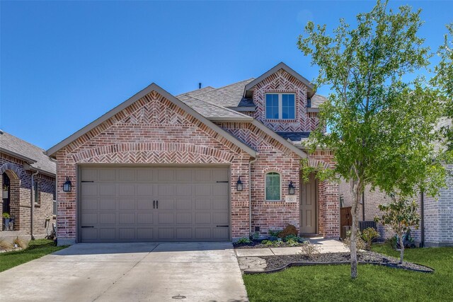 view of front of house with brick siding, a shingled roof, an attached garage, and driveway
