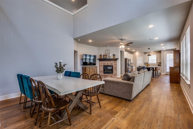 dining area with light wood-style floors, a ceiling fan, and baseboards