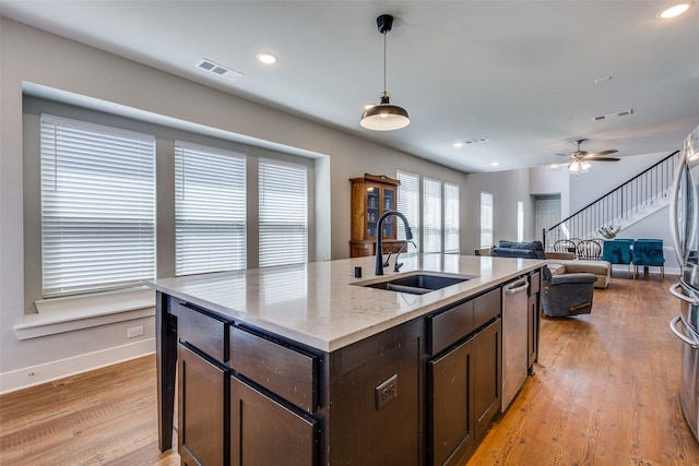 kitchen with visible vents, a sink, baseboards, and dark brown cabinetry
