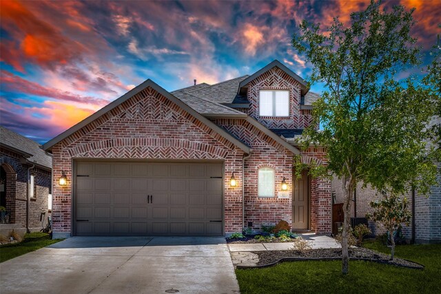 view of front of home with brick siding, an attached garage, and driveway