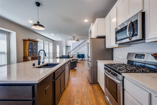 1821 Eagle Lndg, Van Alstyne, TX 75495 - kitchen featuring stainless steel appliances, a sink, white cabinetry, light wood-type flooring, and open floor plan