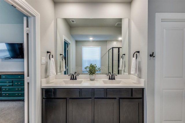 full bath featuring a sink, a shower stall, and double vanity