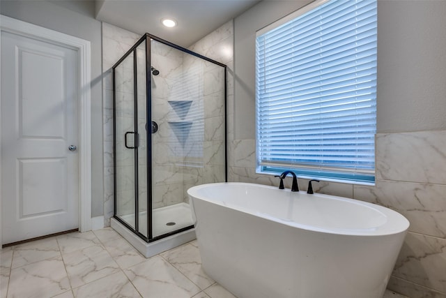 bathroom with a freestanding bath, a shower stall, and marble finish floor
