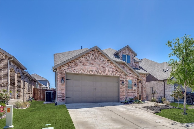 view of front of house with a shingled roof, brick siding, a garage, a front yard, and driveway