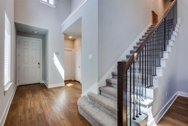 entrance foyer with baseboards, wood-type flooring, and stairs