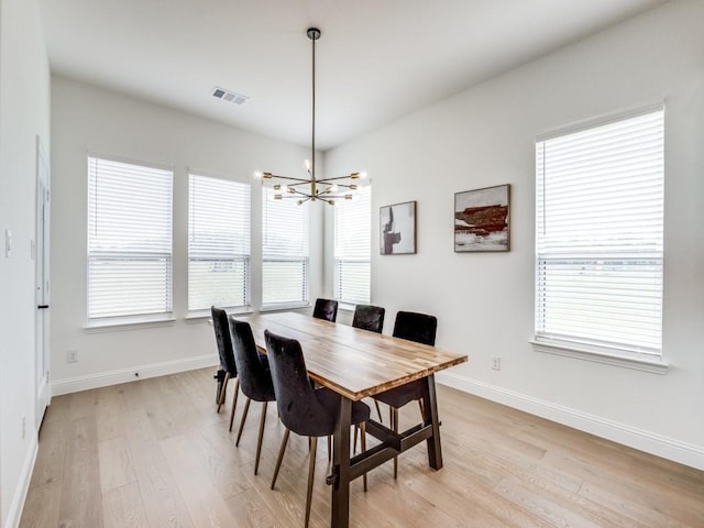 dining room featuring an inviting chandelier, baseboards, light wood-type flooring, and visible vents