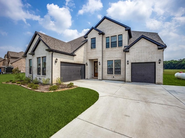view of front of property featuring brick siding, driveway, a shingled roof, and a front yard