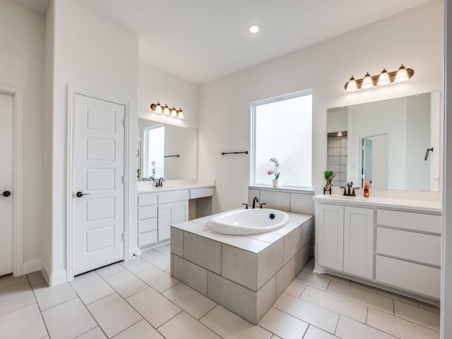 bathroom featuring a garden tub, a sink, tile patterned flooring, and two vanities