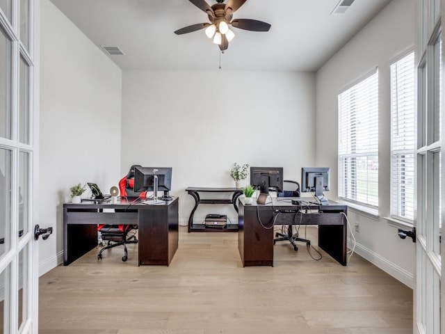 home office featuring visible vents, ceiling fan, wood finished floors, and french doors