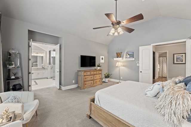 carpeted bedroom featuring baseboards, ceiling fan, vaulted ceiling, and ensuite bath