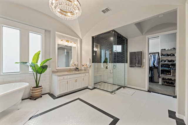 full bath featuring visible vents, a shower stall, vanity, a spacious closet, and a soaking tub