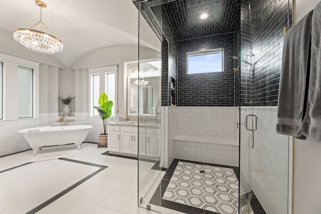 bathroom featuring a freestanding bath, vanity, tile patterned floors, a chandelier, and a shower stall