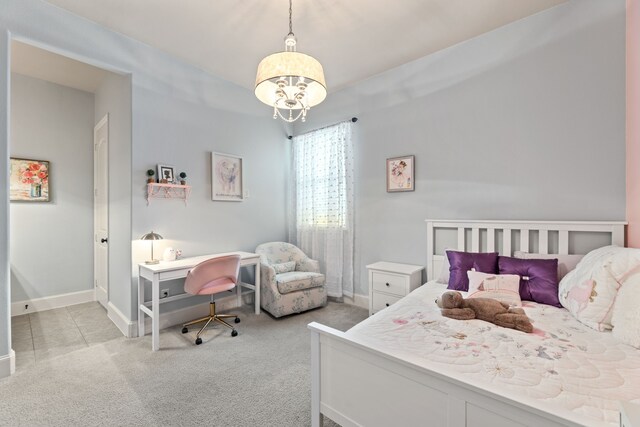 carpeted bedroom with an inviting chandelier and baseboards