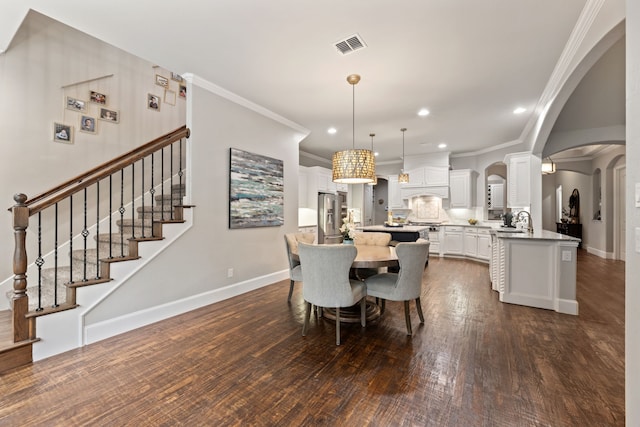 dining space with arched walkways, dark wood finished floors, recessed lighting, baseboards, and visible vents