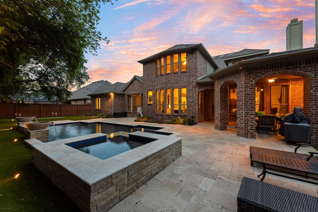 view of swimming pool with a patio area, fence, and an in ground hot tub
