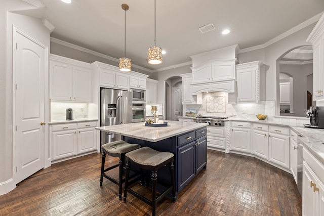 kitchen with arched walkways, recessed lighting, white cabinetry, and stainless steel appliances