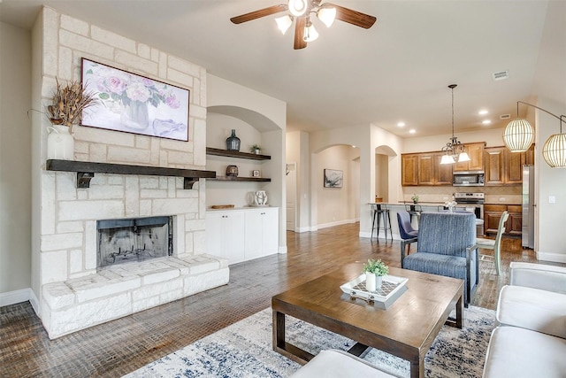 11948 Carlin Dr, Fort Worth, TX 76108 - living area featuring arched walkways, a stone fireplace, a ceiling fan, baseboards, and visible vents