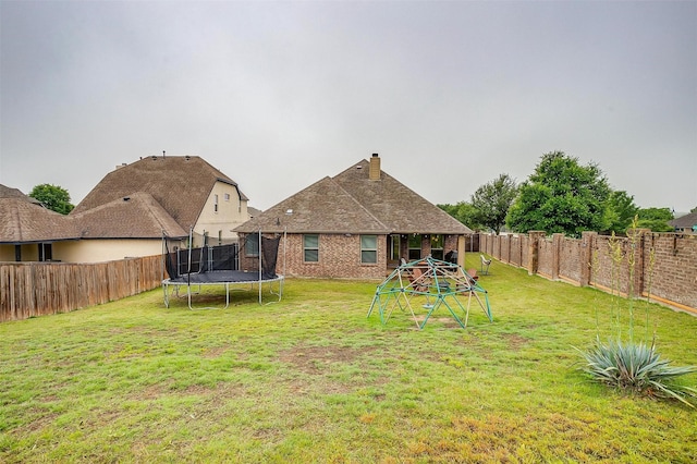 11948 Carlin Dr, Fort Worth, TX 76108 - rear view of property with a yard, a fenced backyard, and a trampoline