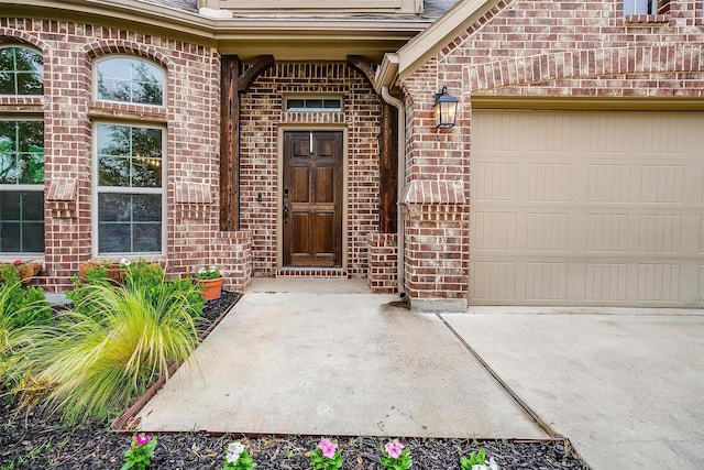 11948 Carlin Dr, Fort Worth, TX 76108 - view of exterior entry featuring concrete driveway, brick siding, and a garage