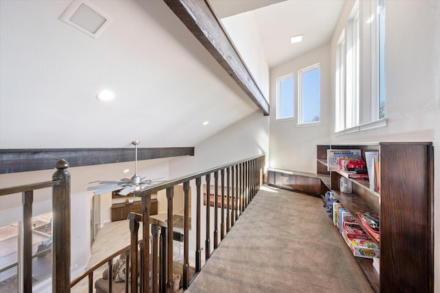 hallway featuring beam ceiling and an upstairs landing