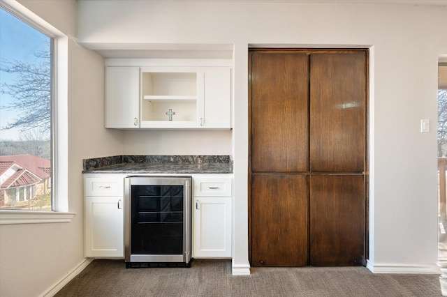 bar with carpet flooring, baseboards, a bar, and wine cooler