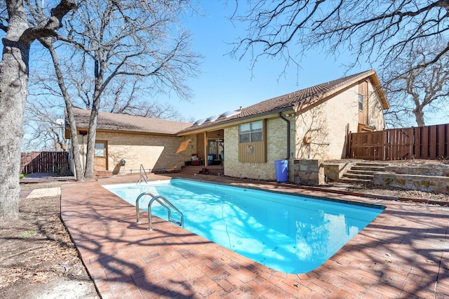 view of swimming pool featuring a fenced in pool, fence, and a patio area