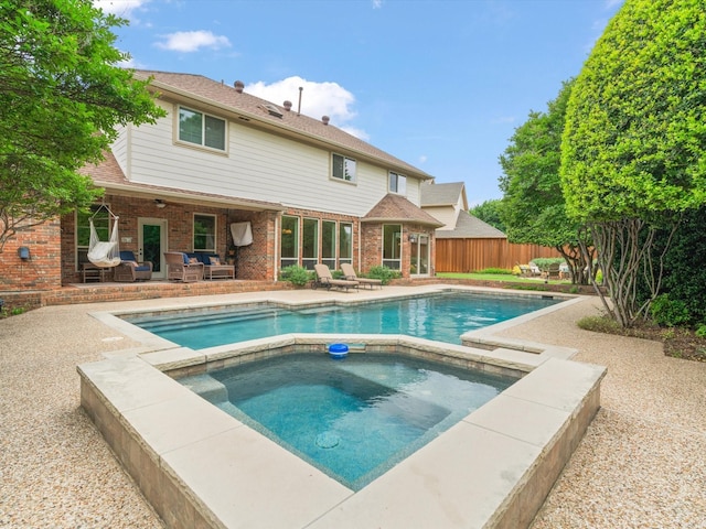 6916 April Way Cir, Plano, TX 75023 - back of house featuring an in ground hot tub, fence, a patio area, brick siding, and a fenced in pool