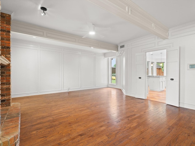 6916 April Way Cir, Plano, TX 75023 - unfurnished living room featuring wood finished floors, a ceiling fan, a decorative wall, beamed ceiling, and ornamental molding